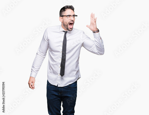 Young handsome business man wearing glasses over isolated background shouting and screaming loud to side with hand on mouth. Communication concept.