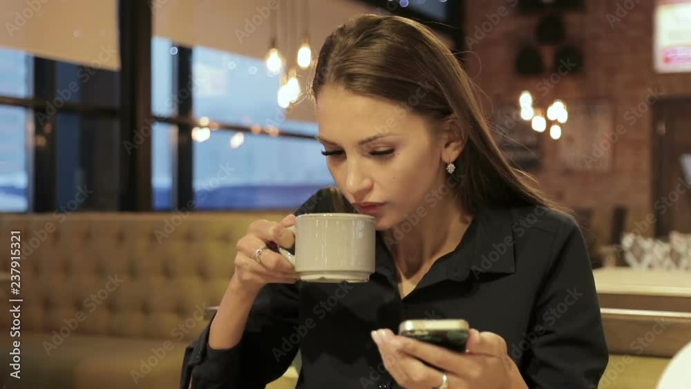 Businesswoman with smartphone drinking coffee in cafe Businesswoman with smartphone drinking coffee in cafe
