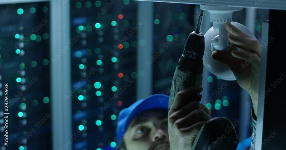 Close-up shot of a male technician installing security camera at a data center