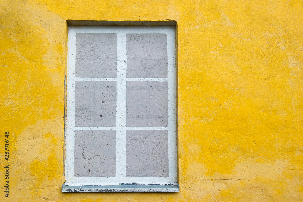 fake or painted window frame on a yellow wall