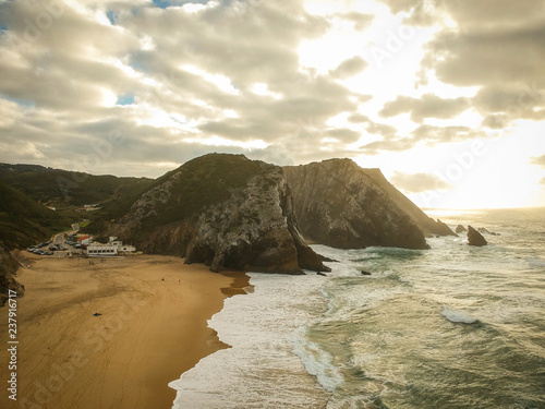 Aerial view from a sandy beach at the sunset with an amazing cliff. Adraga beach Sintra, Portugal photo