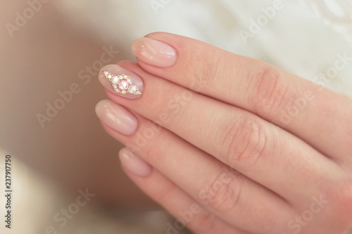 pink manicure with rhinestones on the middle finger close-up