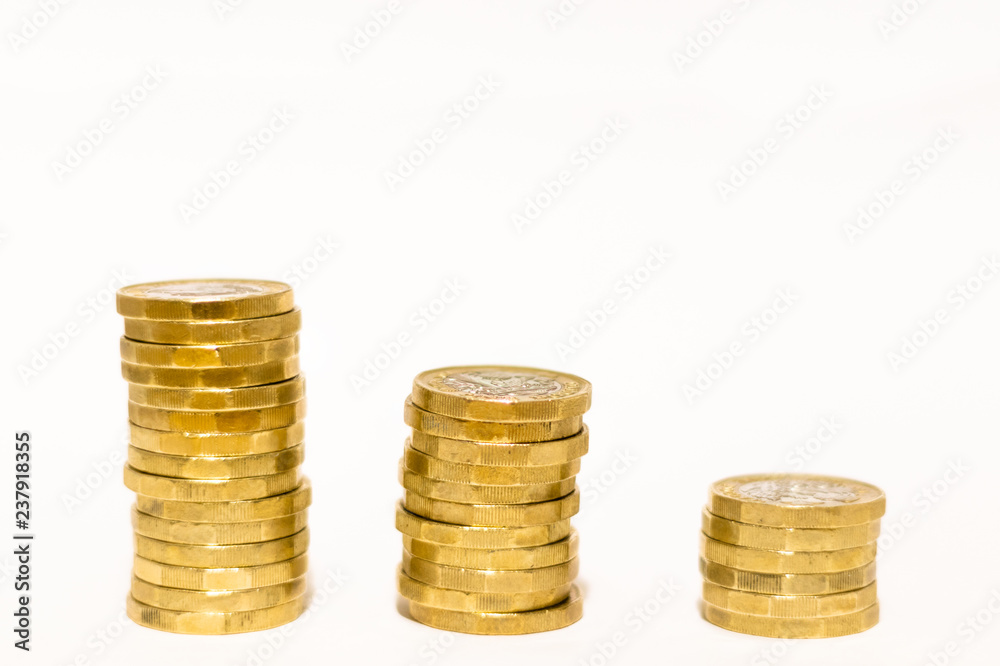 Stacks and Heaps of British GBP Golden Coins Currency Money on white background with empty space Stacks and Heaps of British GBP Golden Coins Currency Money on white background with empty space