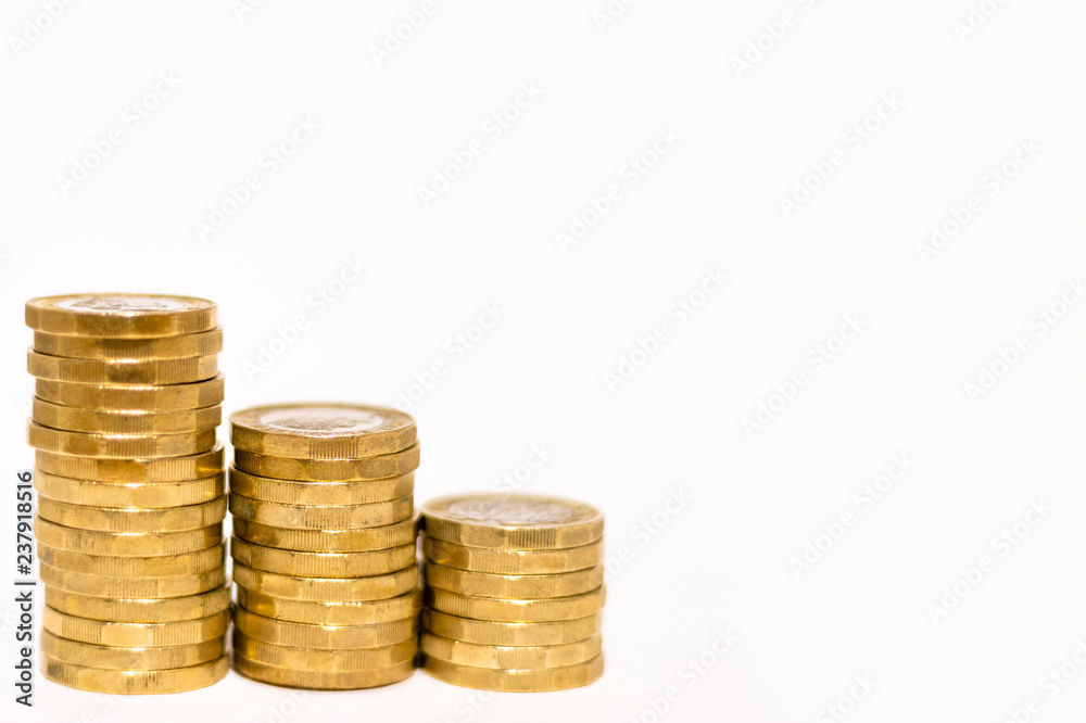 Stacks and Heaps of British GBP Golden Coins Currency Money on white background with empty space Stacks and Heaps of British GBP Golden Coins Currency Money on white background with empty space