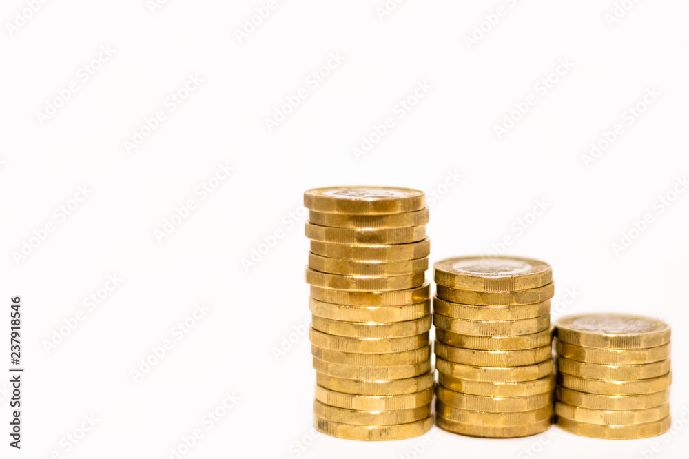 Stacks and Heaps of British GBP Golden Coins Currency Money on white background with empty space Stacks and Heaps of British GBP Golden Coins Currency Money on white background with empty space