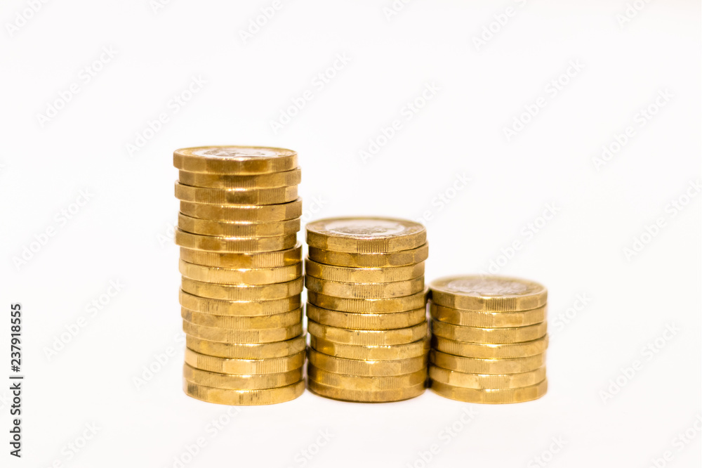 Stacks and Heaps of British GBP Golden Coins Currency Money on white background with empty space Stacks and Heaps of British GBP Golden Coins Currency Money on white background with empty space