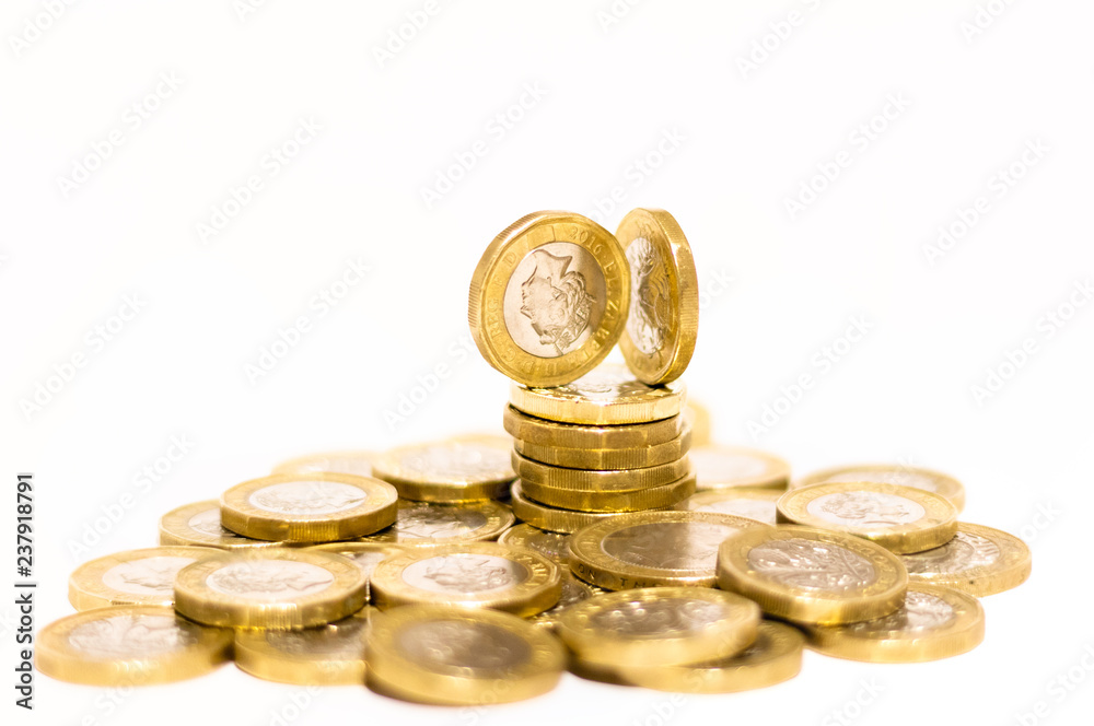 Stacks and Heaps of British GBP Golden Coins Currency Money on white background with empty space