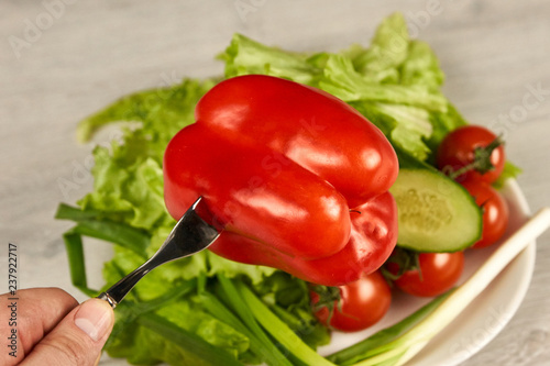 Vegetables in a white plate on a wooden background