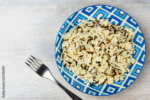 Rice in blue plate on wooden table
