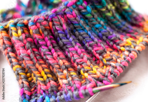 Knitting pattern texture, colorful yarn and needles close-up