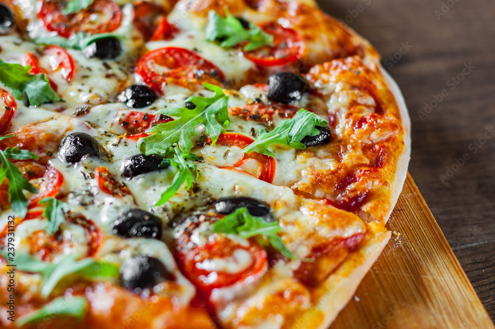 Pizza Margherita or Margarita with Mozzarella cheese, tomato, olive. Italian pizza on wooden background Pizza Margherita or Margarita with Mozzarella cheese, tomato, olive. Italian pizza on wooden background