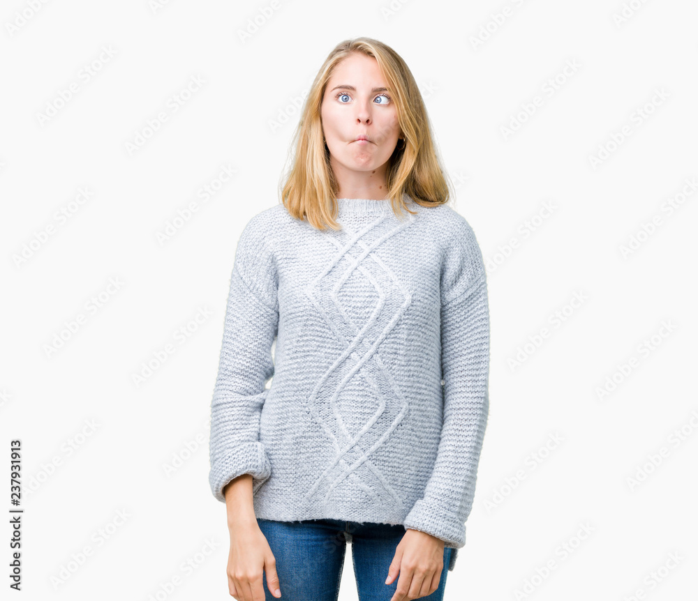Beautiful young woman wearing winter sweater over isolated background making fish face with lips, crazy and comical gesture. Funny expression. Beautiful young woman wearing winter sweater over isolated background making fish face with lips, crazy and comical gesture. Funny expression.