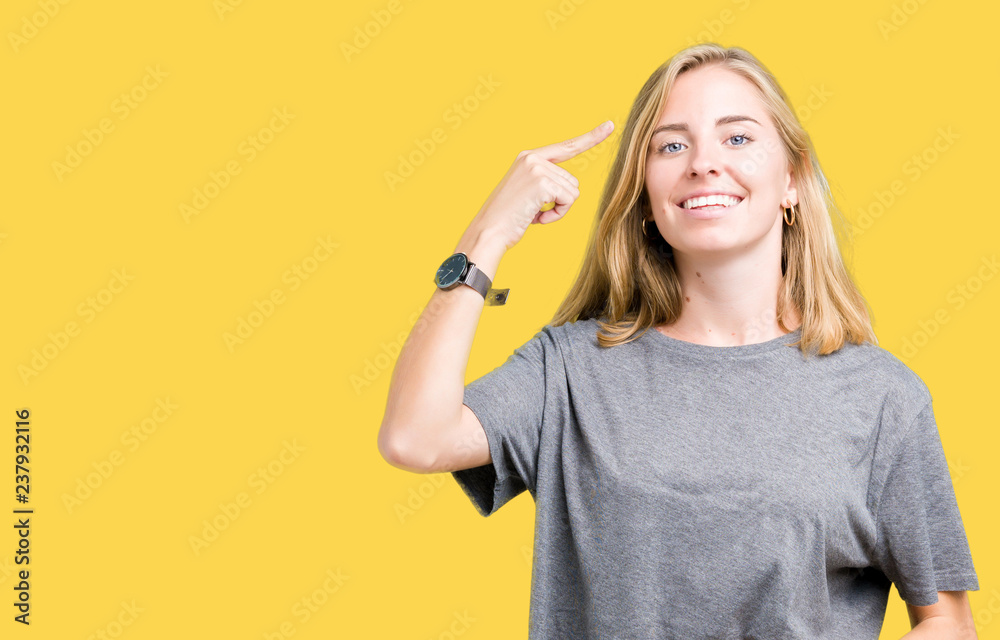 Beautiful young woman wearing oversize casual t-shirt over isolated background Smiling pointing to head with one finger, great idea or thought, good memory Beautiful young woman wearing oversize casual t-shirt over isolated background Smiling pointing to head with one finger, great idea or thought, good memory