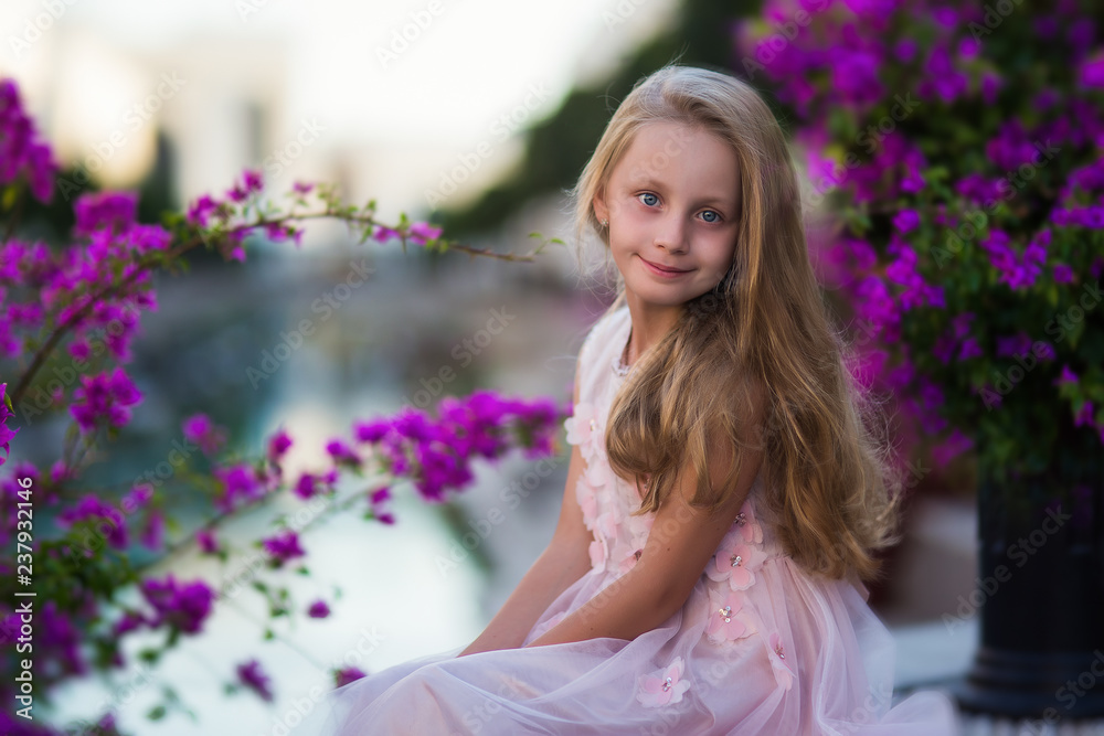 Fototapeta premium Portrait of a cute beautiful girl in princess dress in blooming gardens