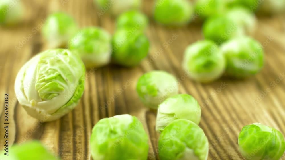 Fresh green brussels sprout vegetables on wood cooking surface. Close up 4k. Fresh green brussels sprout vegetables on wood cooking surface. Close up 4k.