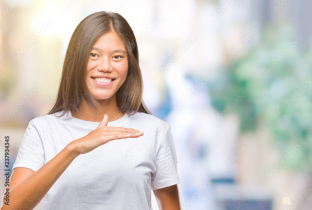 Young asian woman over isolated background gesturing with hands showing big and large size sign, measure symbol. Smiling looking at the camera. Measuring concept.