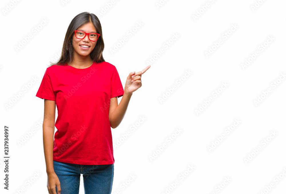 Young asian woman wearing glasses over isolated background with a big smile on face, pointing with hand and finger to the side looking at the camera. Young asian woman wearing glasses over isolated background with a big smile on face, pointing with hand and finger to the side looking at the camera.