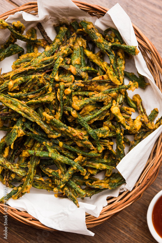 Kurkuri bhindi or crispy ladyfinger or okra fry recipe, served in a bowl with ketchup and hot tea. selective focus photo