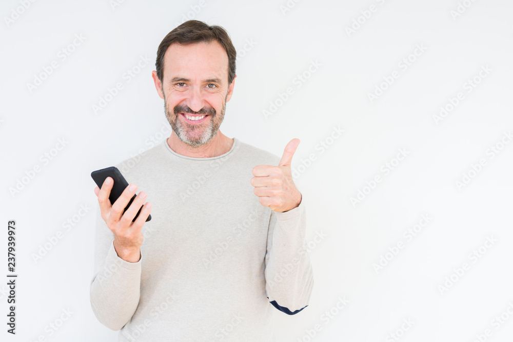 Senior man using smartphone over isolated background happy with big smile doing ok sign, thumb up with fingers, excellent sign Senior man using smartphone over isolated background happy with big smile doing ok sign, thumb up with fingers, excellent sign