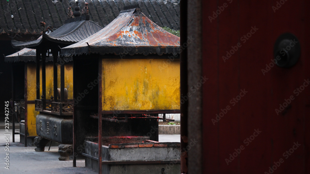 View onto a backyard with yellow candle and incence containers in a historic temple in Suzhou, China, Asia