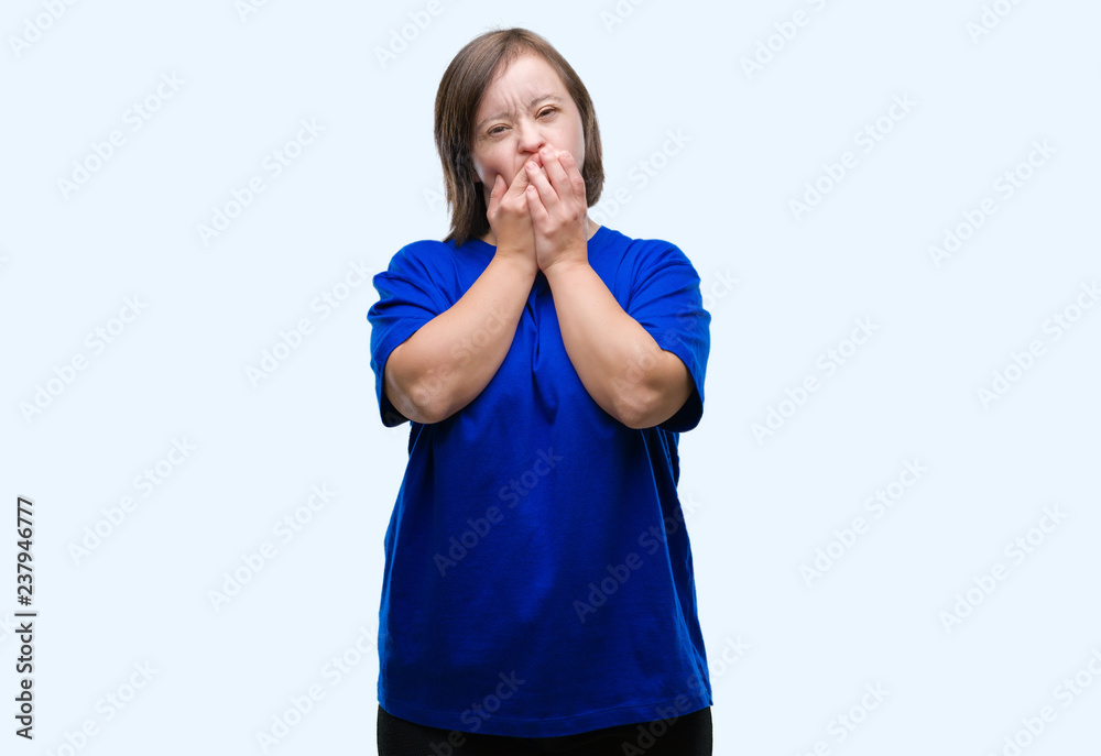 Young adult woman with down syndrome over isolated background shocked covering mouth with hands for mistake. Secret concept. Young adult woman with down syndrome over isolated background shocked covering mouth with hands for mistake. Secret concept.
