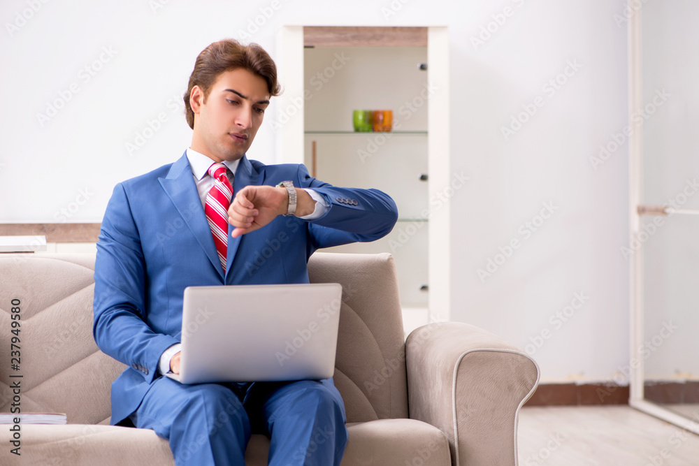 Young businessman working at home sitting on the sofa Young businessman working at home sitting on the sofa