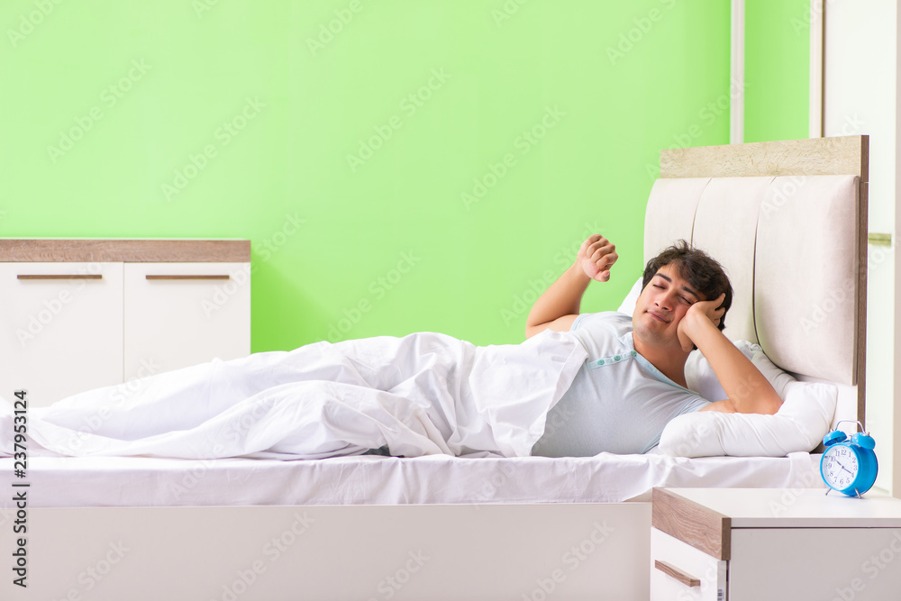 Young man having trouble waking up in early morning Young man having trouble waking up in early morning