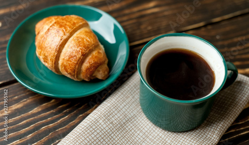 Fototapeta Naklejka Na Ścianę i Meble -  mug of coffee, croissant on wooden background