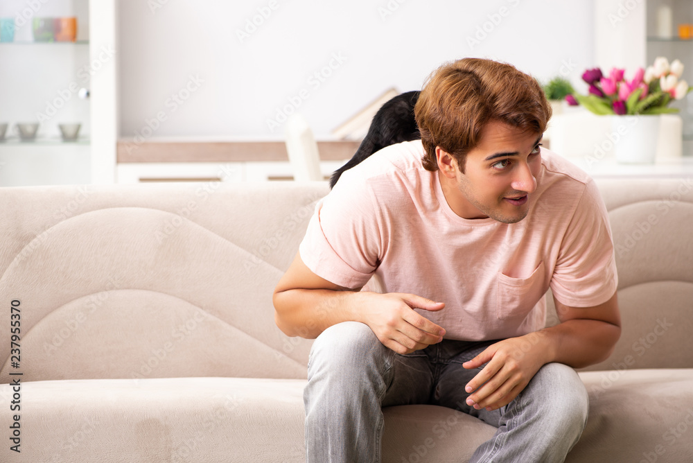 Young man playing with kitten at home Young man playing with kitten at home
