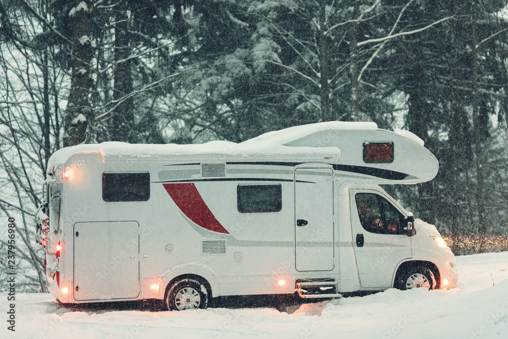 campervan caravan vehicle for van life holiday on camper van journey camping in mountains near the forest in the winter adventure season. snowing on the camper outdoor nomad lifestyle