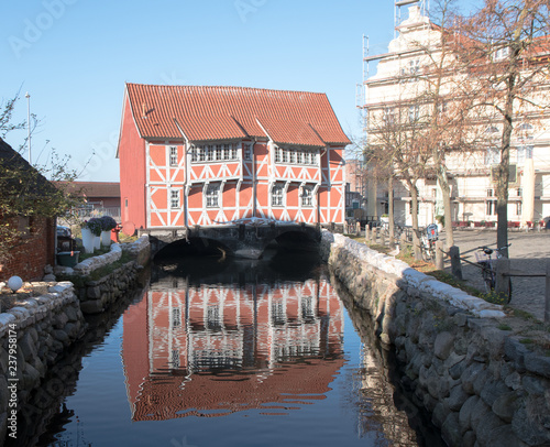 Historical half-timbered house, called Brueckenhaus (bridge house), spans the canal to the harbor of Wismar in Mecklenburg-Vorpommern, Northern Germany photo