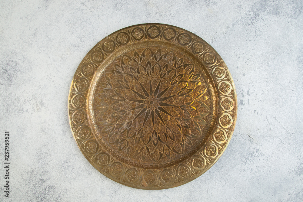 Vintage brass plate with embossed floral pattern