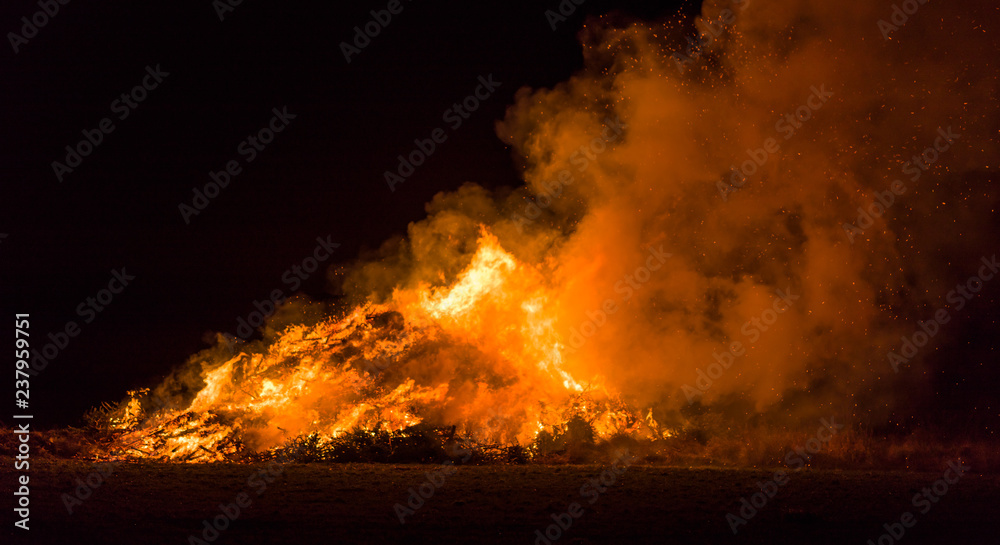 Christmas trees burning intensively on a field at night