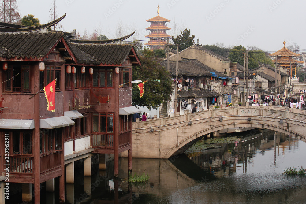 View from a bridge towards old traditional buildings, a buddhist temple pagoda and the channel in Qibao old town Shanghai, China