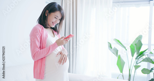 Fotografie pregnant woman use smart phone