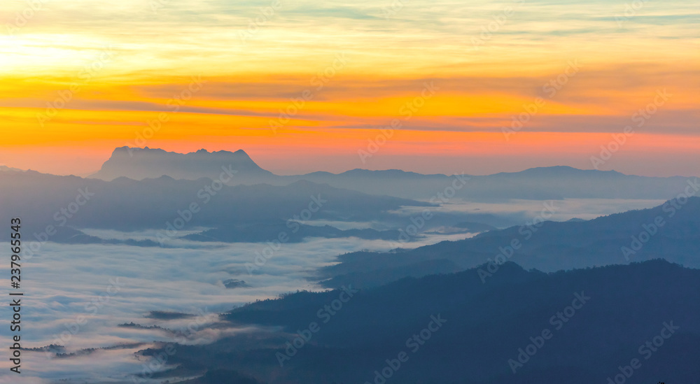 Mountain and foggy at morning time with orange sky, beautiful landscape in the thailand