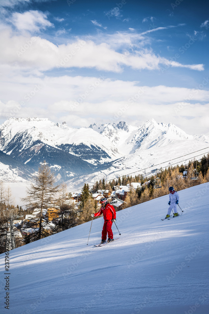 Two people skiing on a ski slope at La Plagne in the French Alps in Savoie, France