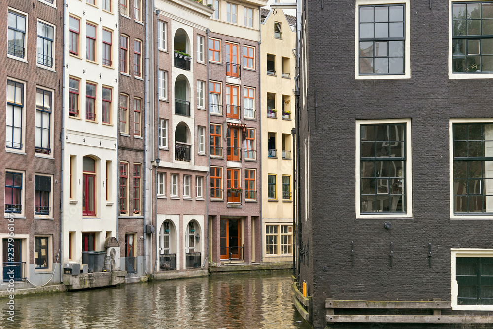 View of the old historical buildings near of the one of the water canals in the center part of Amsterdam. Netherlands.