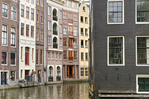 View of the old historical buildings near of the one of the water canals in the center part of Amsterdam. Netherlands.