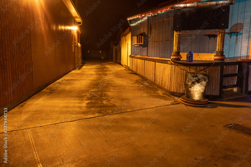 Yellow light illuminating an empty alley at night, Kapa'a, Kaua'i, Hawai'i
