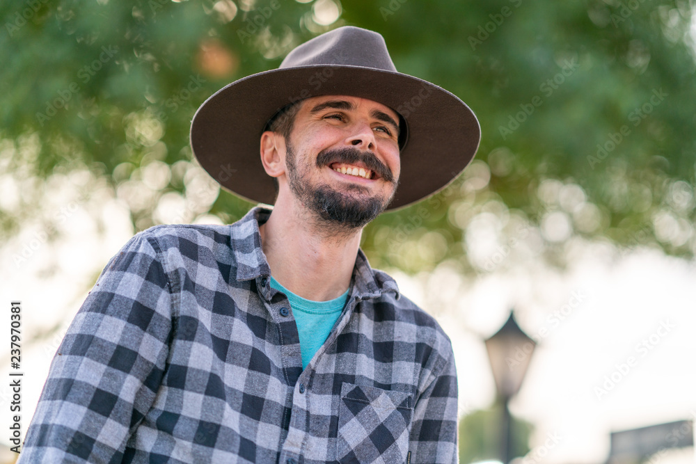 Cowboy with grey hat, moustache and checkerboard shirt
