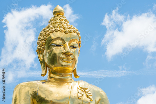 Close-up of Big golden Buddha statue with Lanna style located at Golden triangle the area where the borders of Thailand, Laos, and Myanmar meet at Mekong rivers. Chiang Rai province of Thailand.
