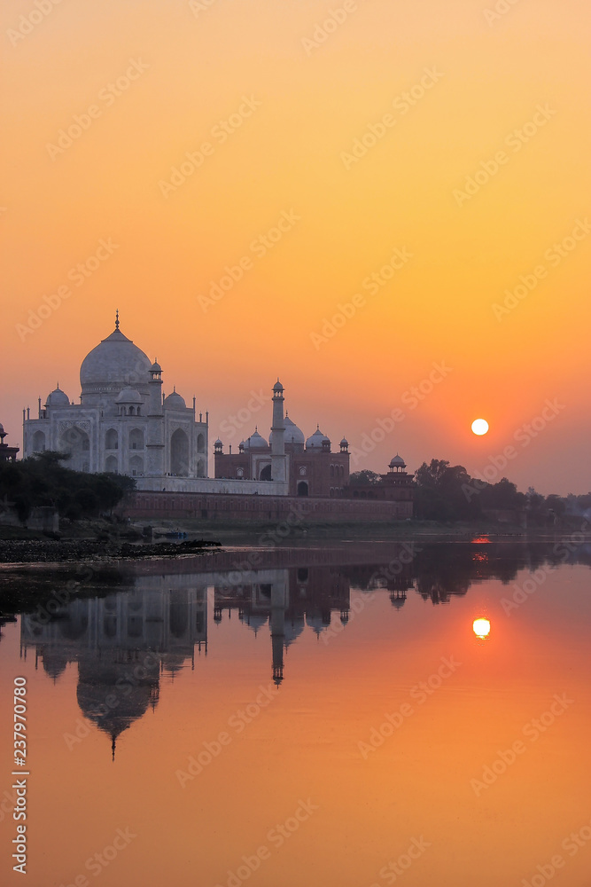 Taj Mahal reflected in Yamuna river at sunset in Agra, India
