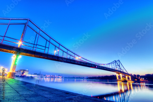 Pedestrian bridge in Kyiv, shoted in dusk illuminated with different colors