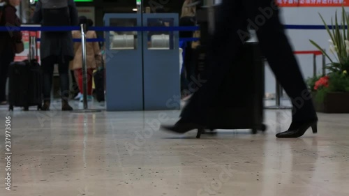 Travelers passengers in airport transit terminal walking with luggage baggage going traveling. People walking inside the terminal.