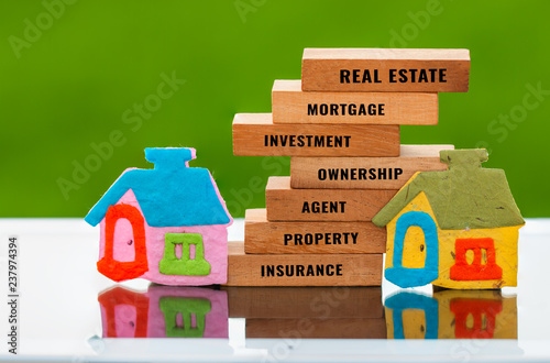 Home for mortgage and real estate concept: House model with wooden blocks on green background for letter e.g investment,agent,ownership,property, insurance etc. Idea show management for dream life