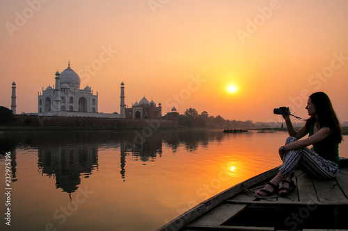 Принти на полотні Woman watching sunset over Taj Mahal from a boat, Agra, India