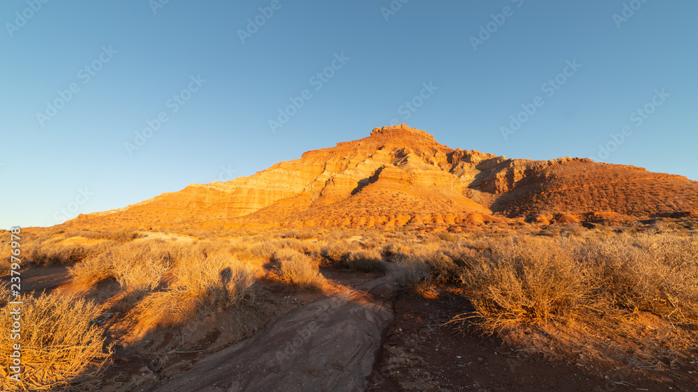A sandy wash leads towards Gooseberry mesa as the sun sets on a winter day in Southern Utah.