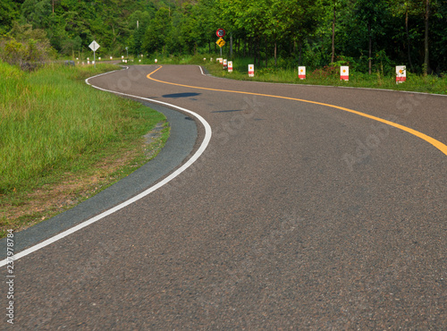 Winding road in mountain. Summer day road trip. Serpentine road perspective photo. New asphalt road curve.