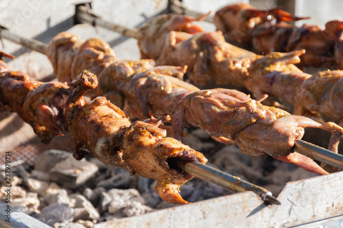 grilling quails over charcoal stove